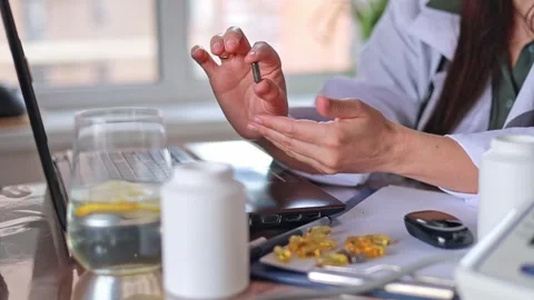 Close-up Doctor shows dark oval capsules and pills. Alternative medicine Stock Footage 310867079