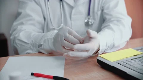 Close-up The doctor at the table puts on disposable gloves. Stock Footage 145614099