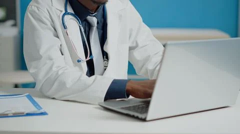 Close up of doctor typing on laptop keyboard in medical cabinet Stock Photos
