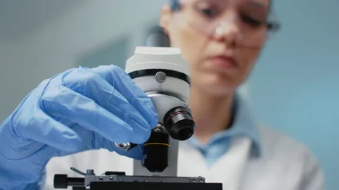 Close up of doctor using optical lens on microscope Stock Footage 157598514