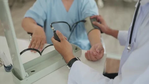 Close up doctor using pressure gauge checking the an male patient blood pressure Stock Footage 265997789