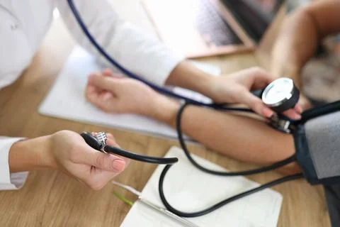 Close up of doctor using sphygmomanometer with stethoscope checks blood pressure Stock Photos