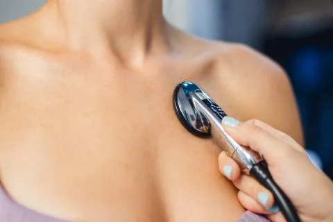 Close up of doctor using stethoscope to exam woman patient heart. Stock Photos