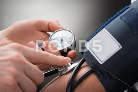 Close-Up Of A Doctor's Hand Checking Blood Pressure Of A Patient
