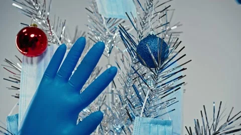 Close-up of doctors hand decorating Christmas tree with masks, gloves and balls Stock Footage 143531699