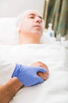 Close up of doctor's hand squeezing patient's hand Stock Photos