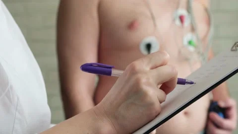 Close-up doctor's hand writing in patient's chart. Holter monitoring. Stockbeeldmateriaal 208860016