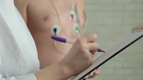 Close-up doctor's hand writing in patient's chart. Holter monitoring. Stock Footage 218219463