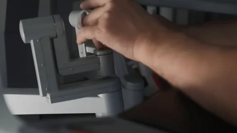 Close-up of doctor's hands controlling complex technological medical robot Stock Footage 243531262
