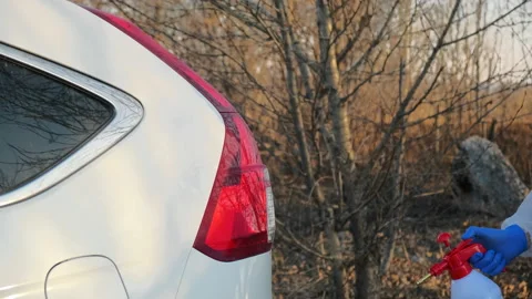 Close-up of doctor's hands during a virus outbreak disinfects a car outdoors Stock Footage 130772598
