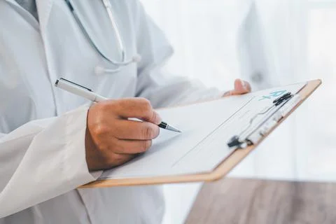 Close-up of doctors' hands jotting down something on the Medical Prescribtion Stock Photos