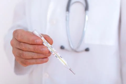 Close-up of doctor's hands showing thermometer Stock Photos