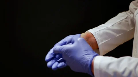 Close up of doctor's hands taking off his nitrile gloves. Stock Footage 127578891