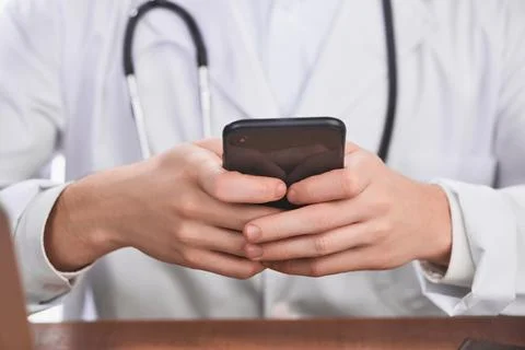 Close-up on doctor's hands using a cell phone Foto stock