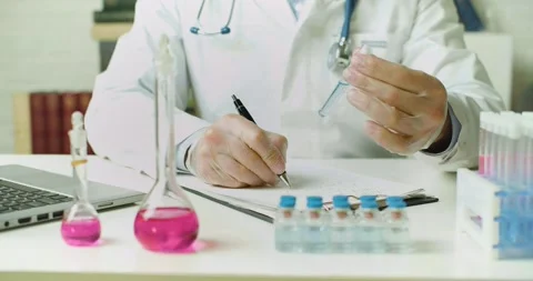 Close-up of a doctor's hands with a vaccine sample in a test tube - he is Stock Footage 168789689