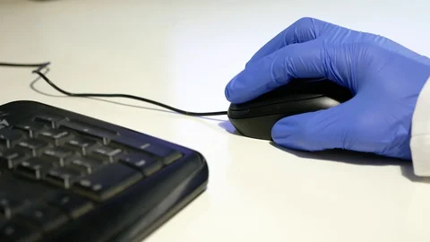 Close up of doctor's hands wearing nitrile gloves using a computer mouse. Stock Footage 128323692