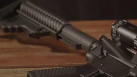 Close dolly from buttstock to trigger group of loaded AR-15 on a wooden 库存影片 171110759