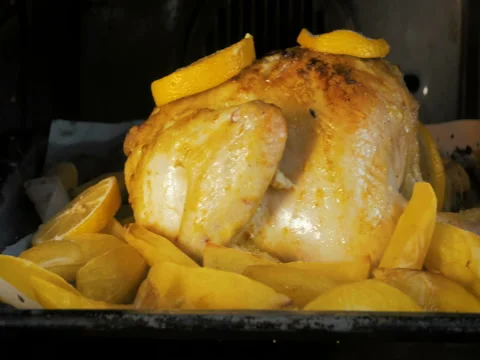 Close-up dolly in the oven prepare an appetite chicken with potatoes. Video stock 80447721