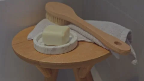 Close-Up Dolly Shot of Bath Accessories on Wooden Table by Bathtub Stock Footage 304092665