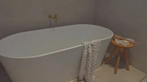 Close-Up Dolly Shot of Bath Gold Accessories Wooden Table by Bathtub Stock Footage 304092599