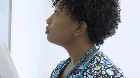 Close-up dolly shot of nurse using tablet computer while reading reports on Stock Footage 96401865