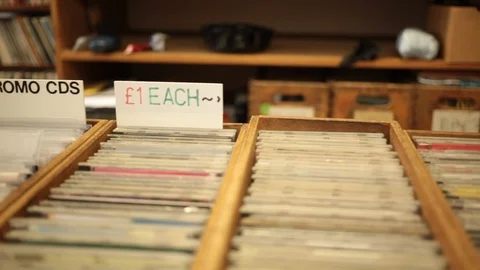Close up dolly shot of racks of CD's for sale in music store Stock Footage 98741809