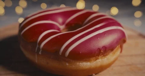 Close-up Dolly shot of a red donut on a bokeh background. Stock Footage 100875125
