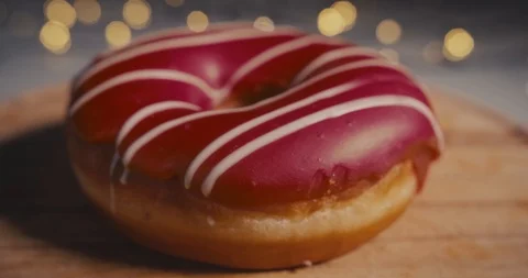 Close-up Dolly shot of a red donut on a bokeh background. Stock Footage 100875143
