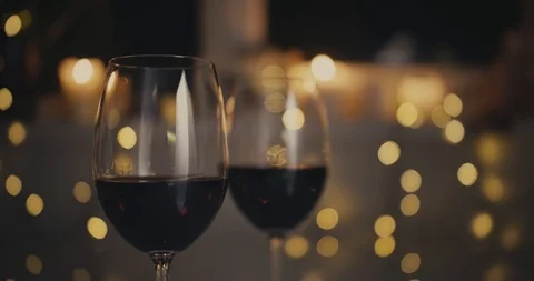 Close-up dolly shot. Two glasses are lifted by a male and female hand. Bokeh Stock Footage 100875255