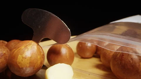 Close Up Dolly Slider Shot of Macadamia Nuts with Special Metal Key Opening Hard 動画素材 324559742