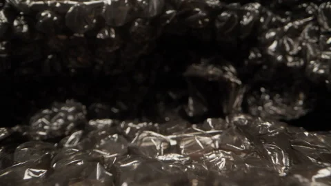 Close up dolly slider shot moving across black bubble wrap packaging material wi Video stock 330878134