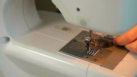 Close up dolly of woman's hands sewing material in sewing machine and taking it Stock Footage 115630491