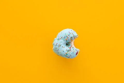 Close up donut with bite missing isolated on yellow background Foto stock