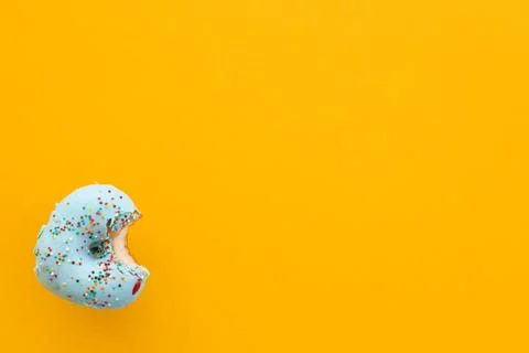 Close up donut with bite missing isolated on yellow background Stock Photos