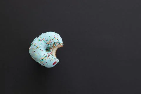 Close up donut with bite missing isolated on black background Stock Photos