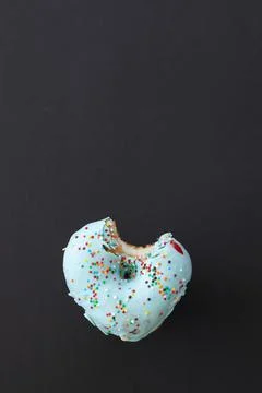 Close up donut with bite missing isolated on black background Stock Photos