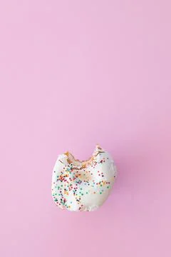 Close up donut with bite missing isolated on pink background Stock Photos