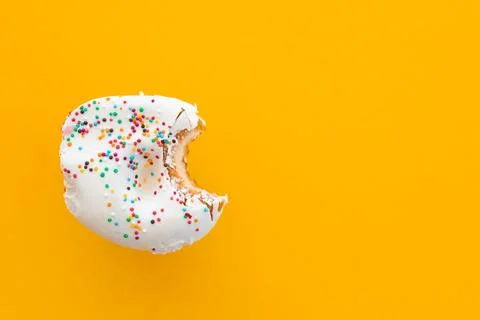 Close up donut with bite missing isolated on color background Stock Photos