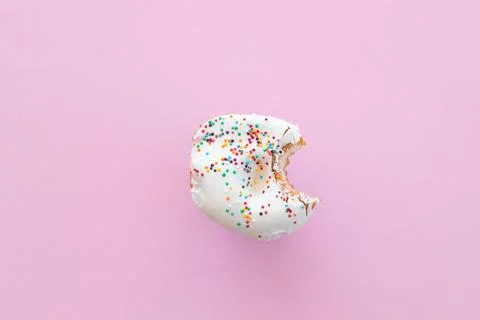 Close up donut with bite missing isolated on pink background Stock Photos
