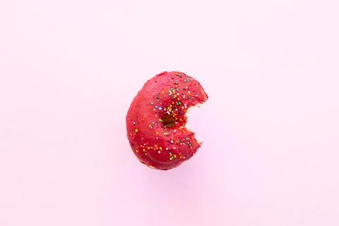 Close up donut with bite missing isolated on color background Stock Photos