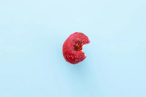 Close up donut with bite missing isolated on color background Foto stock