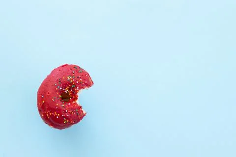 Close up donut with bite missing isolated on color background Foto stock