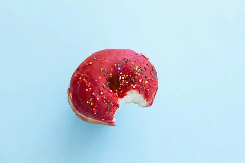Close up donut with bite missing isolated on color background Stock Photos