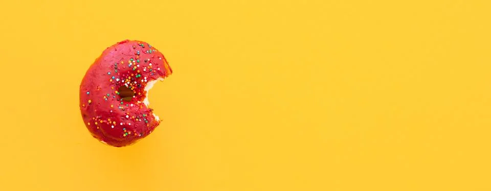 Close up donut with bite missing isolated on color background Stock Photos