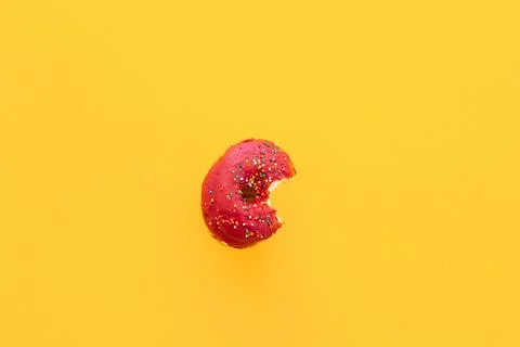 Close up donut with bite missing isolated on color background Stock Photos