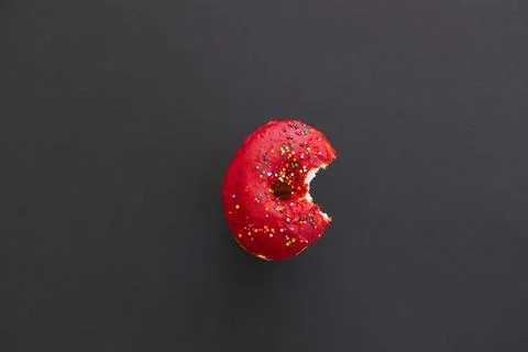 Close up donut with bite missing isolated on color background Foto stock