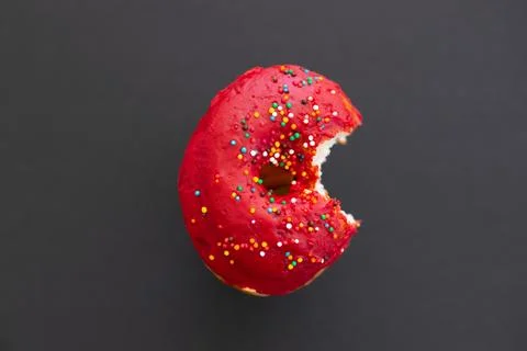 Close up donut with bite missing isolated on color background Stock Photos