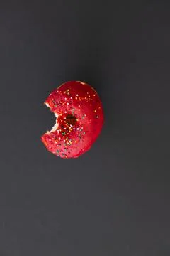 Close up donut with bite missing isolated on color background Foto stock