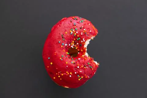 Close up donut with bite missing isolated on color background Foto stock