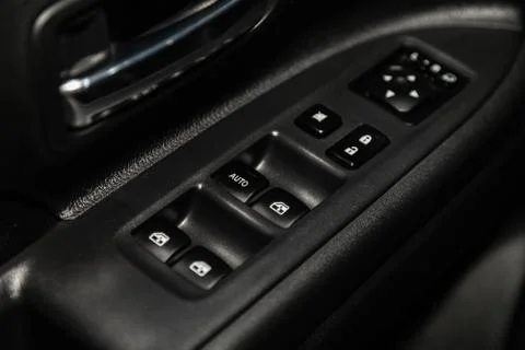 Close up of a door control panel in a new modern car. Arm rest with window co Stock-Fotos
